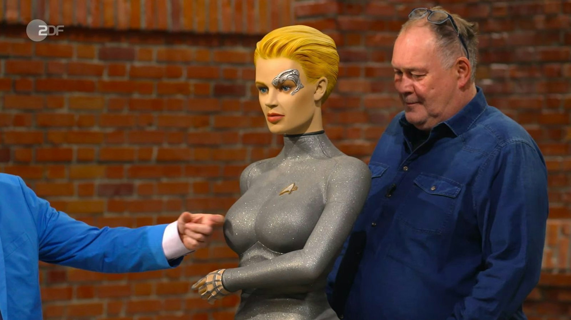 Nanu, wer hatte sich denn diesmal in „Bares für Rares“-Studio verirrt? Walter „Waldi“ Lehnertz war sich sicher: „Das ist bestimmt vom E.T die Frau!“. Nun ja, fast ... (Bild: ZDF)