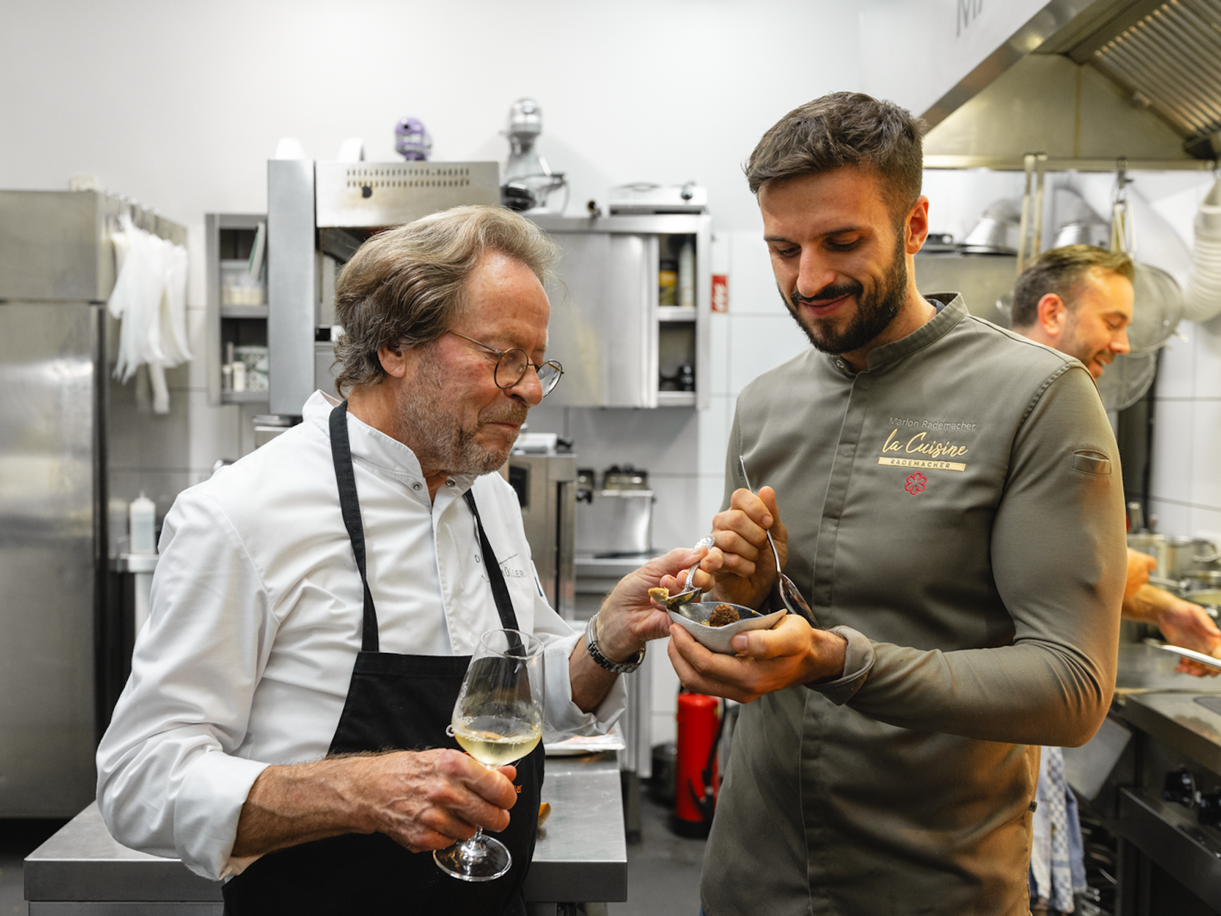 Dieter Müller (links) und Marlon Rademacher kosten Crème brûlée von der Gänseleber, einen Klassiker Müllers, beim Charity-Dinner für die Stiftung Kinderherz in Rademachers Restaurant „La Cuisine“.