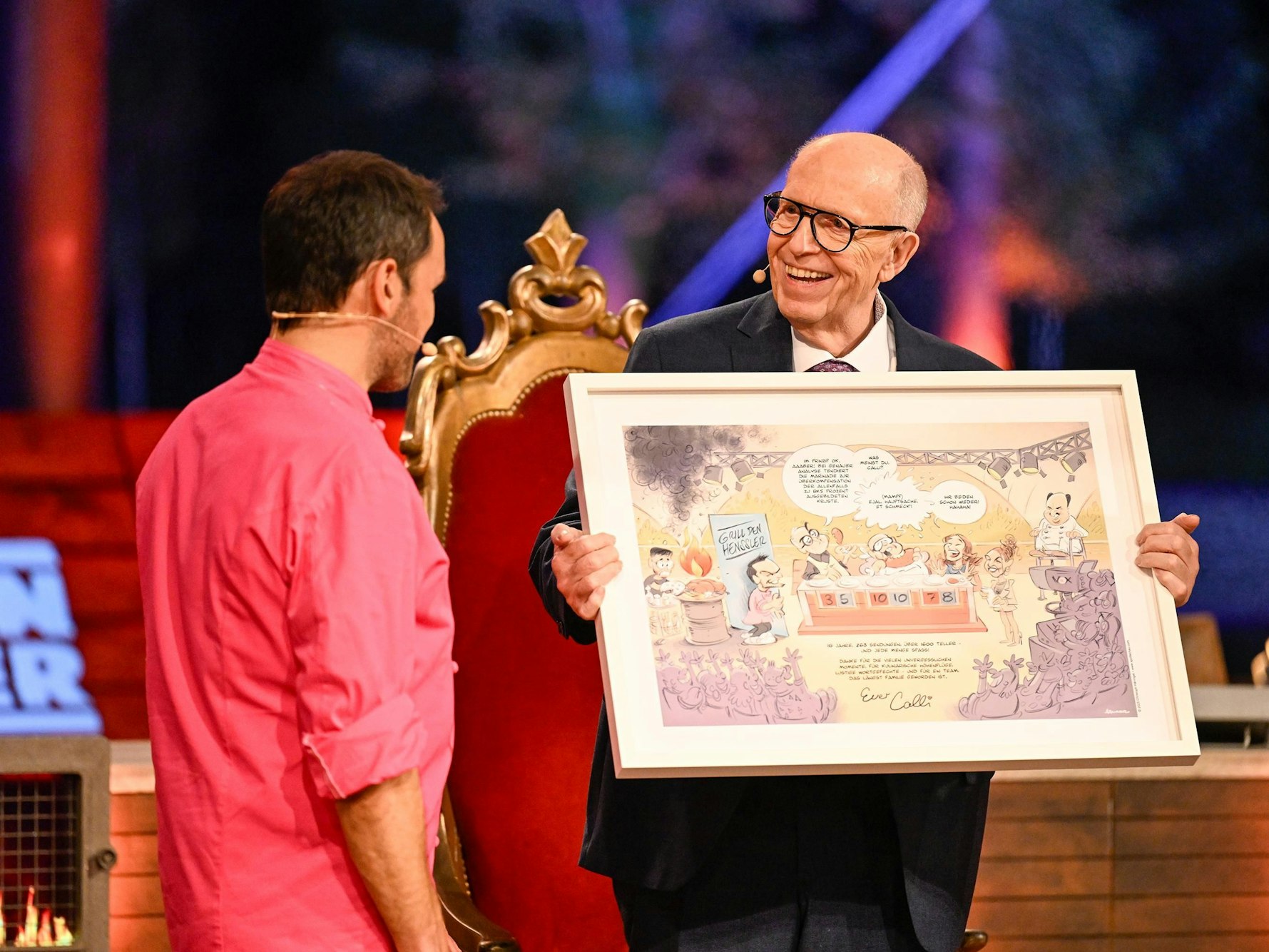 Reiner Calmund überreicht Steffen Henssler eine Karikatur.