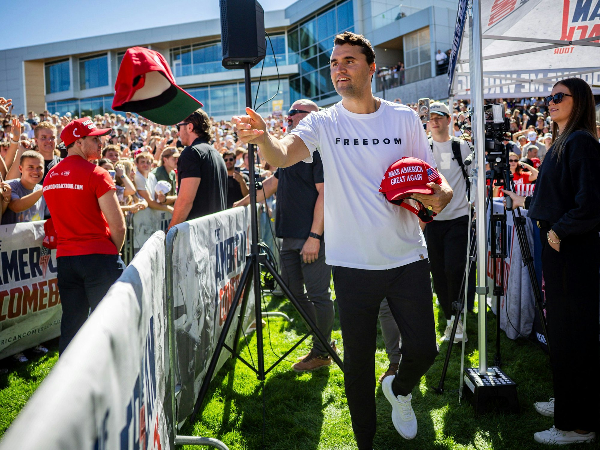 Charlie Kirk verteilt vor seiner Rede an der Utah Valley University Mützen.