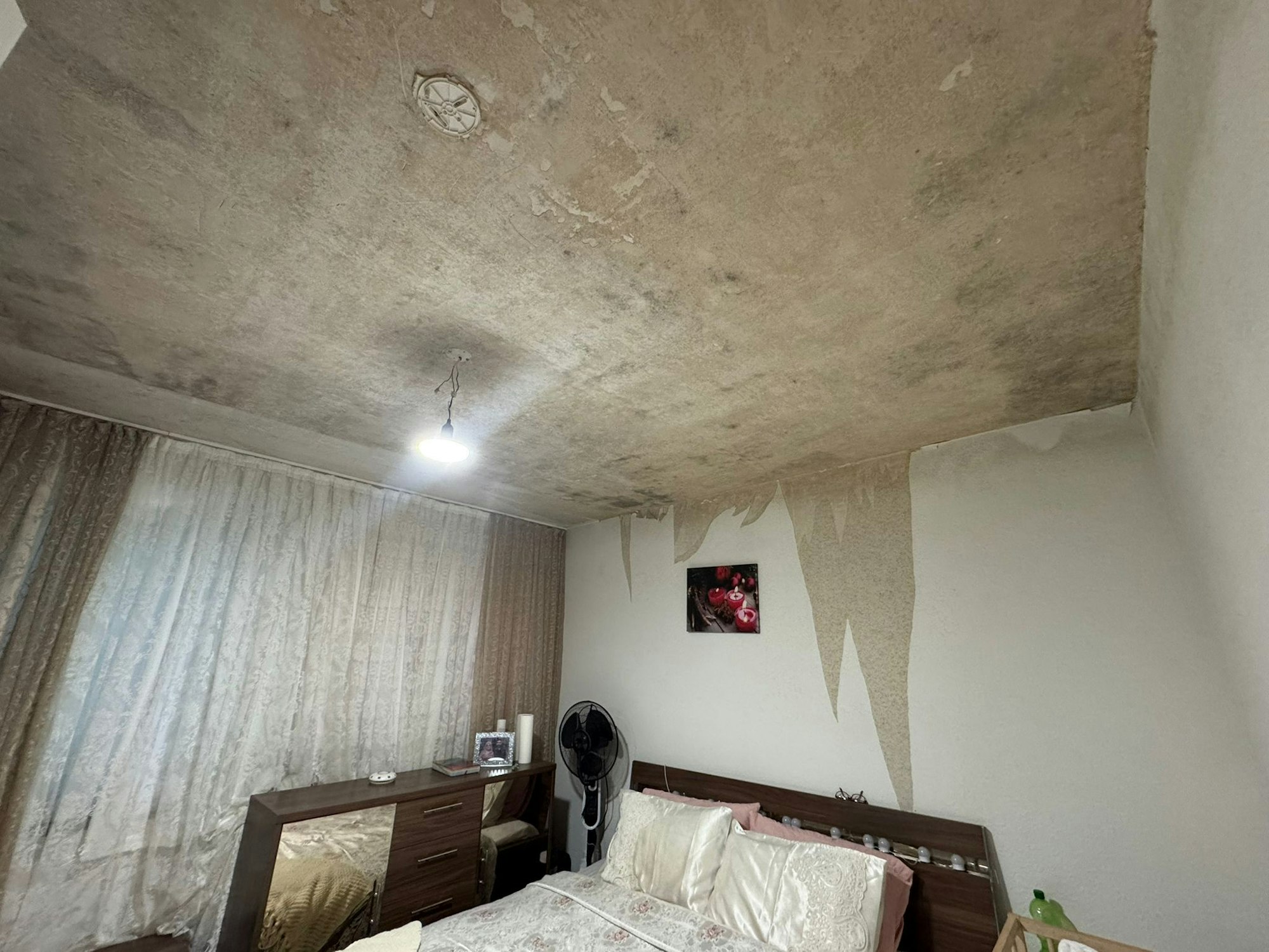 Auch im Schlafzimmer sind die heftigen Wasserschäden an Decke und Wänden deutlich sichtbar.