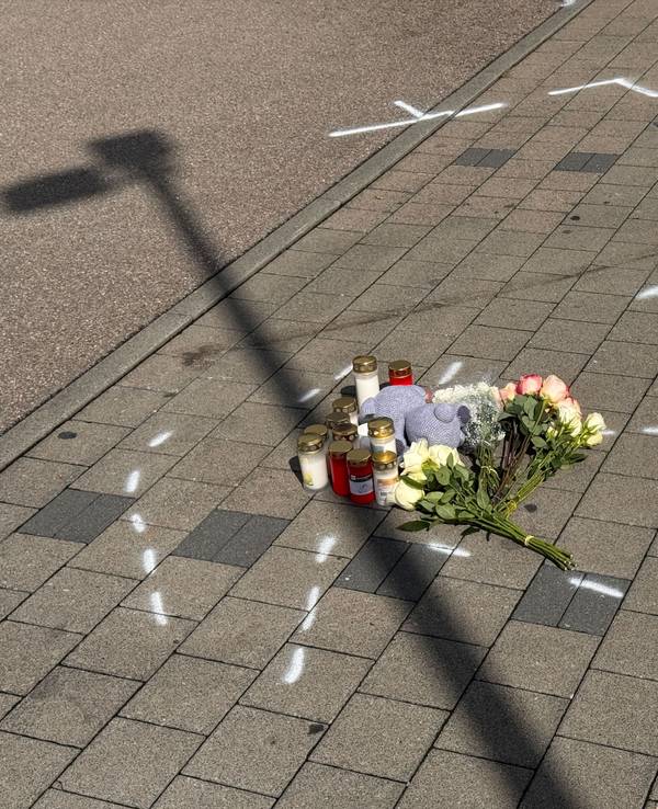 Markierungen mit Sprühfarben und Trauerbekundungen sind auf einem Parkplatz zu sehen. Nach einem Streit auf einem Parkplatz soll ein 18-Jähriger einen 12 Jahre alten Jungen in Niedernhall (Hohenlohekreis) mit dem Auto verfolgt, angefahren und tödlich verletzt haben.