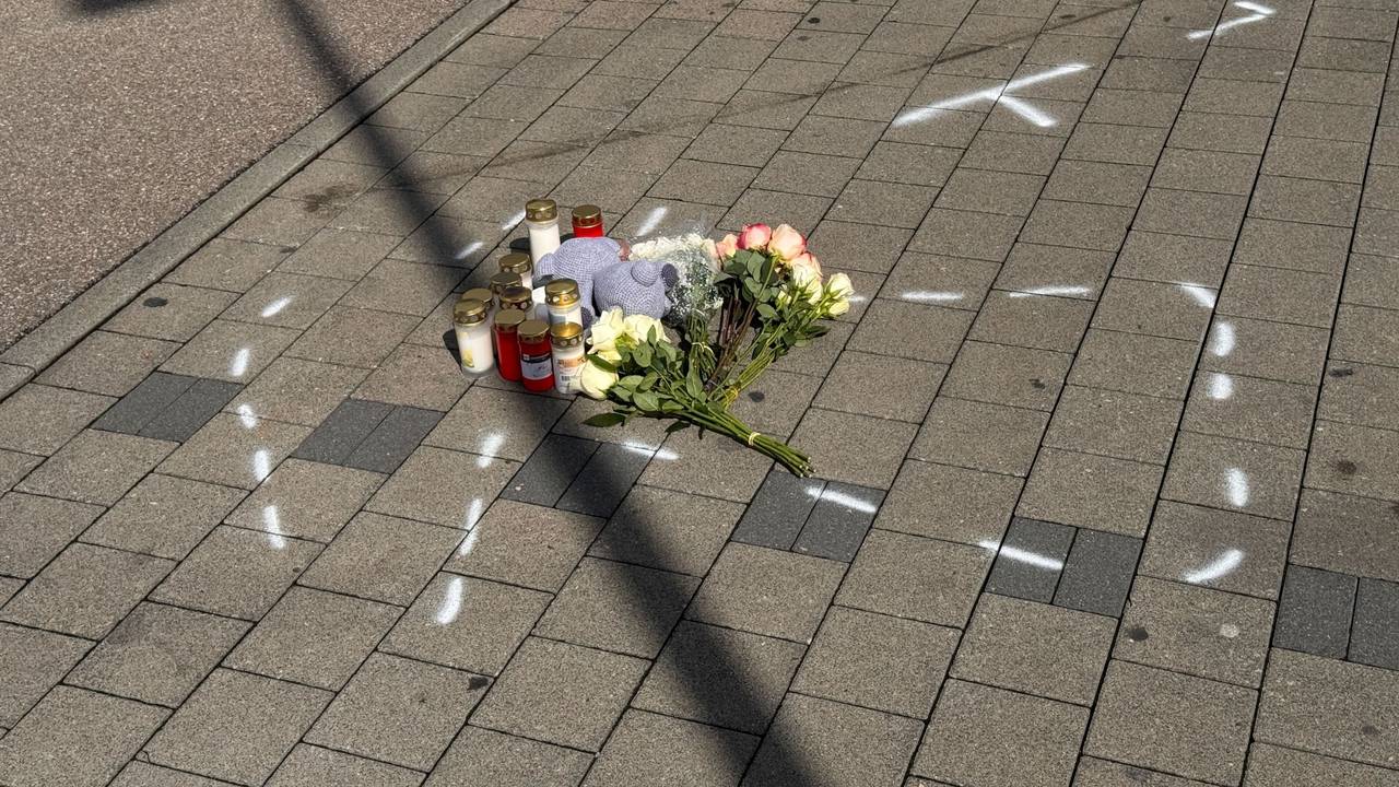 Markierungen mit Sprühfarben und Trauerbekundungen sind auf einem Parkplatz zu sehen. Nach einem Streit auf einem Parkplatz soll ein 18-Jähriger einen 12 Jahre alten Jungen in Niedernhall (Hohenlohekreis) mit dem Auto verfolgt, angefahren und tödlich verletzt haben.