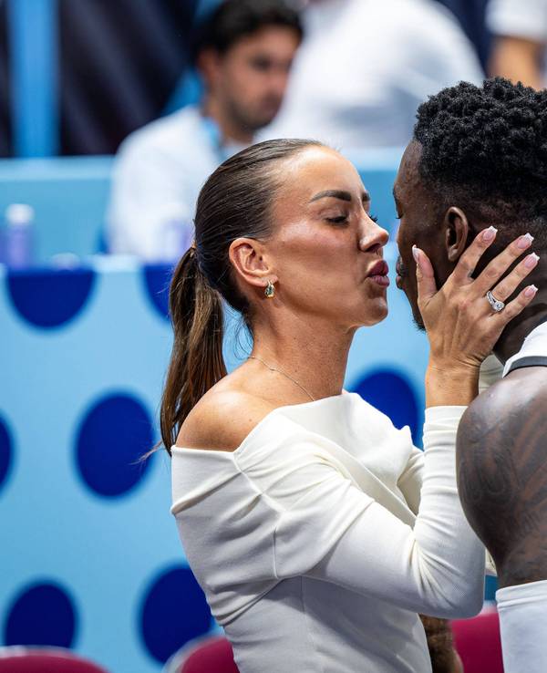 Dennis Schröder und seine Ehefrau Ellen küssen sich am Spielfeldrand.