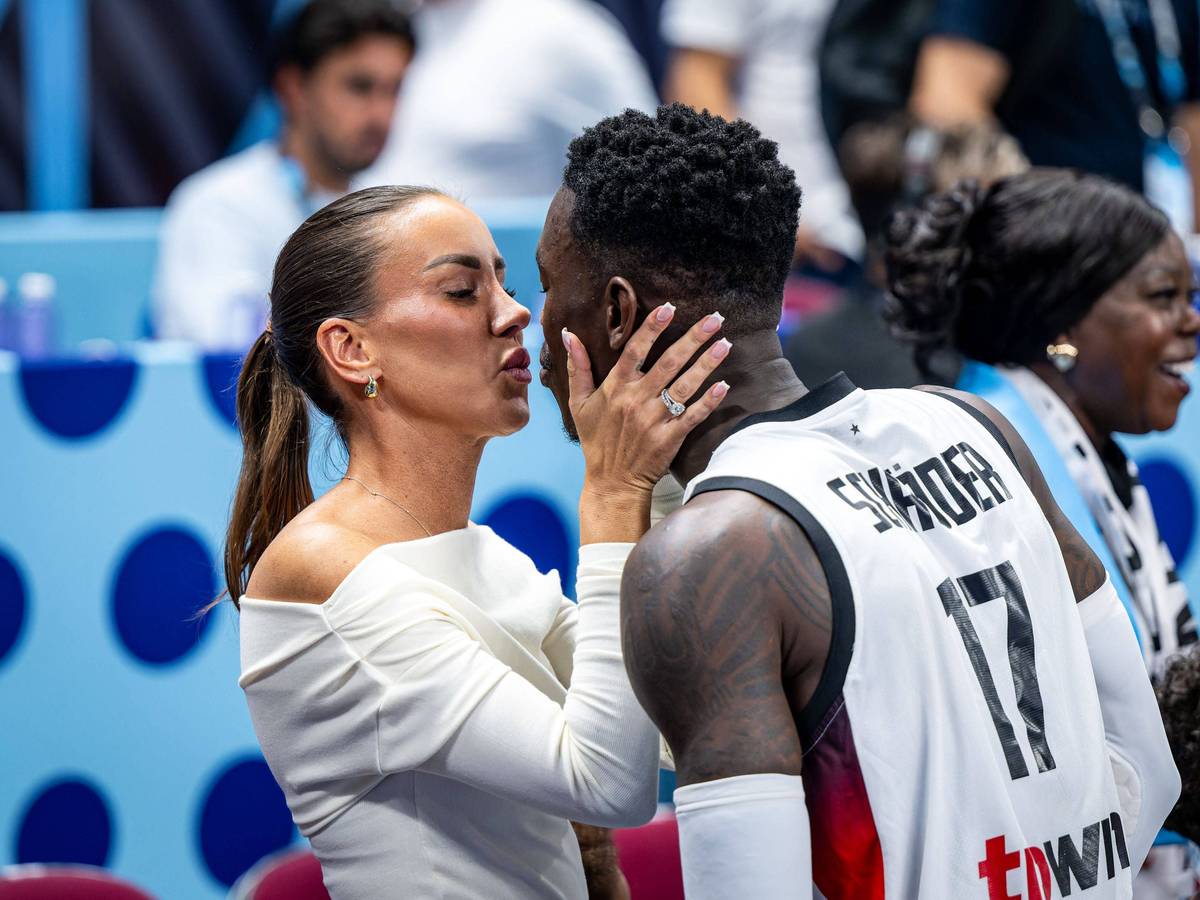 Dennis Schröder und seine Ehefrau Ellen küssen sich am Spielfeldrand.