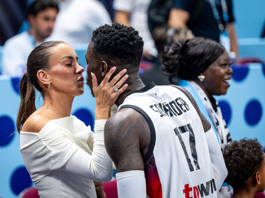 Dennis Schröder und seine Ehefrau Ellen küssen sich am Spielfeldrand.