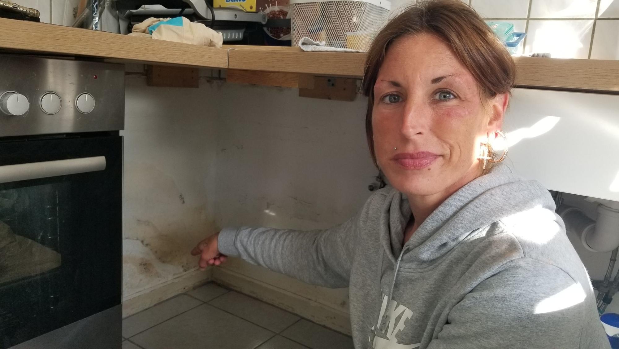 Maria Thiel (35) zeigt einen der vielen Wasserschäden in der Küche ihrer Wohnung in Köln-Flittard.