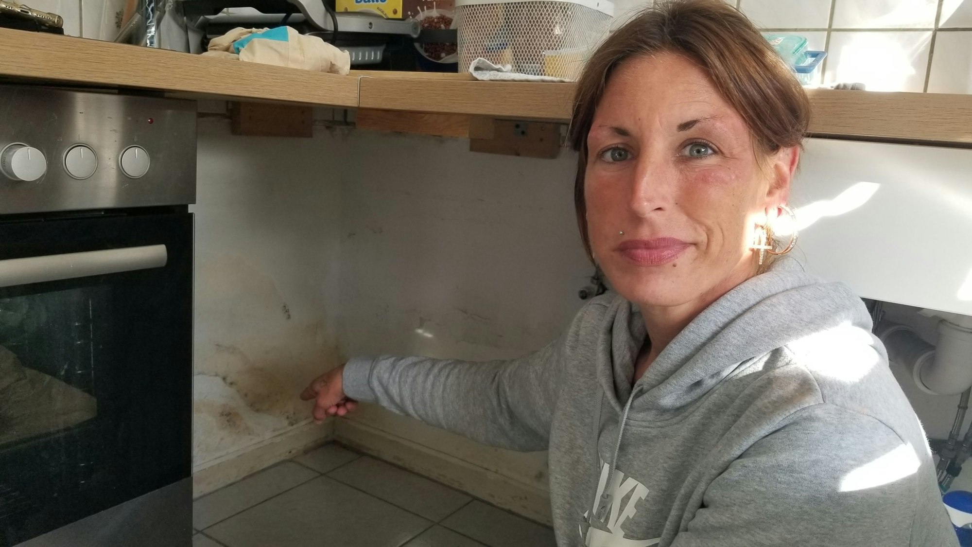 Maria Thiel (35) zeigt einen der vielen Wasserschäden in der Küche ihrer Wohnung in Köln-Flittard.