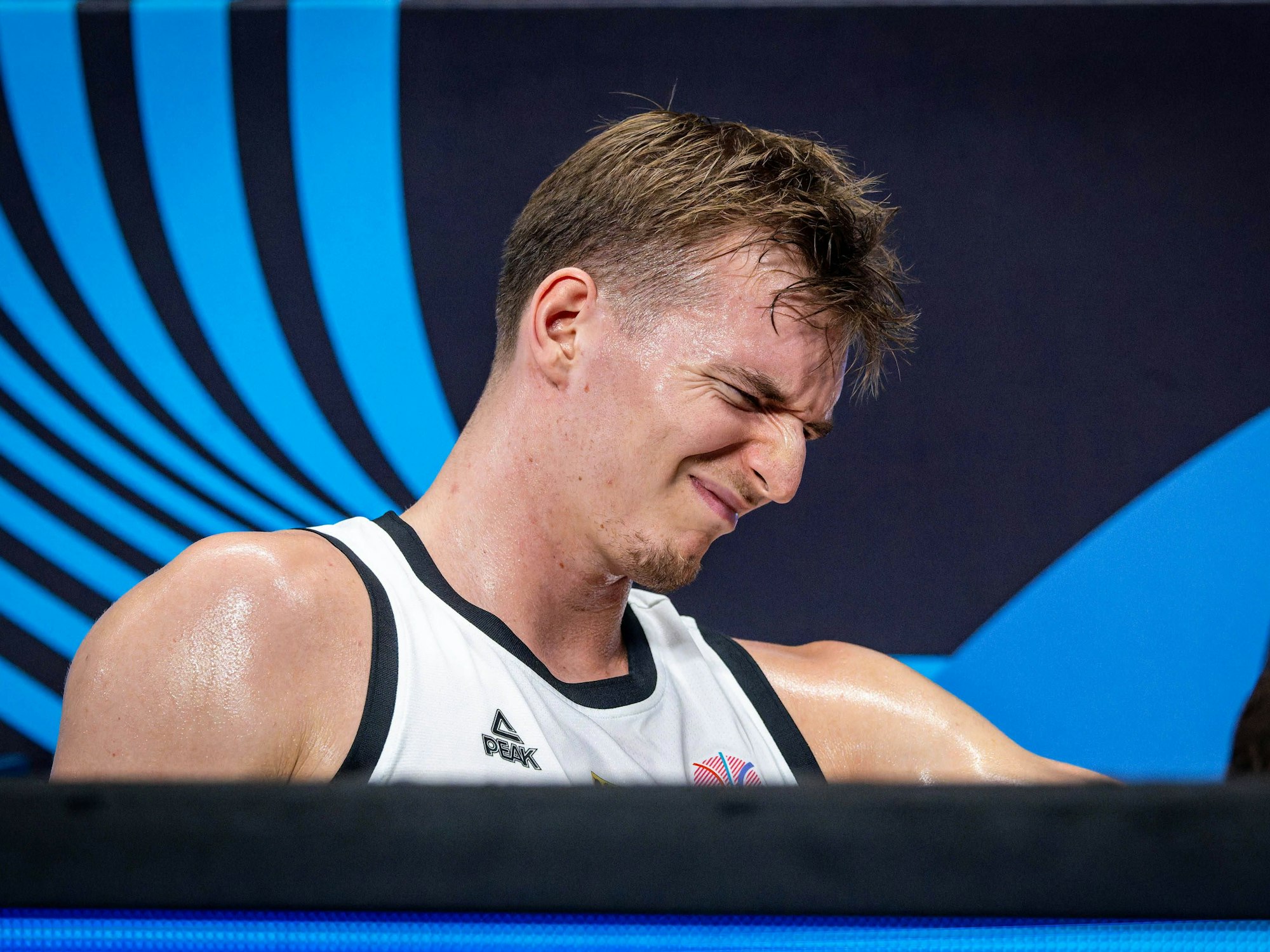 Justus Hollatz sitzt mit schmerzverzerrtem Gesicht an der Seitenlinie beim Spiel gegen Slowenien am 10. September 2025.