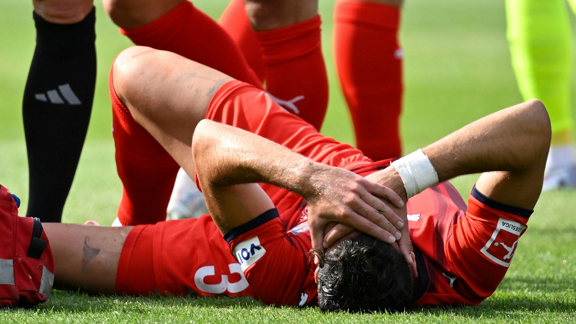 Leart Pacarada hält sich nach seiner Knieverletzung die Hände vors Gesicht.