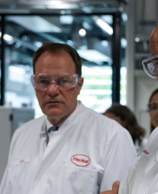 Bundeskanzler Friedrich Merz (CDU, r) besichtigt das Werk der Henkel AG in Düsseldorf