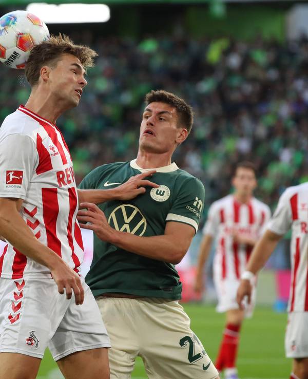 Joel Schmied (1. FC Köln) mit einem Hinterkopfball gegen Joakim Maehle (VfL Wolfsburg) am 13. September 2025.