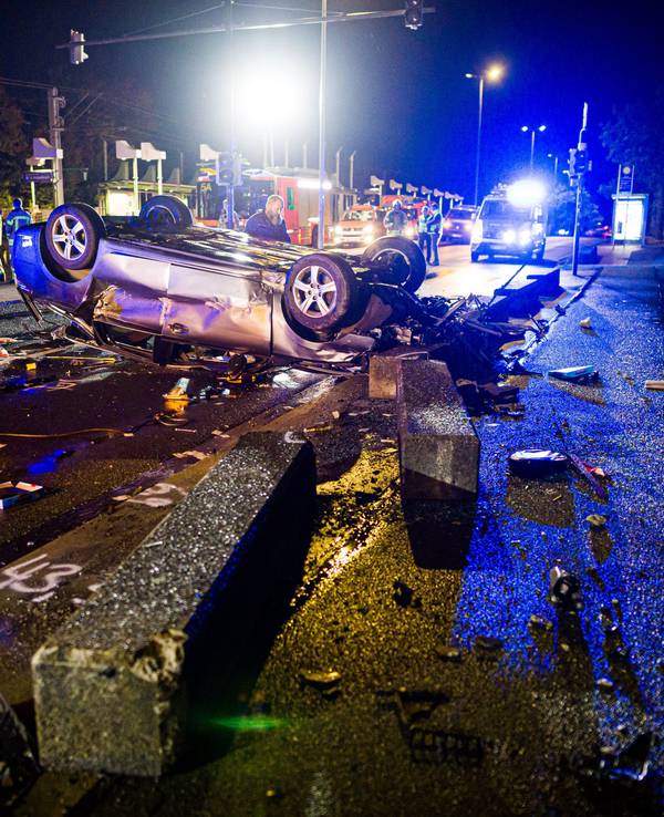 14.09.2025, Niedersachsen, Hannover: Ein verunfalltes Auto liegt auf dem Dach auf einer Brücke hinter Betonbaken. Foto: Moritz Frankenberg/dpa +++ dpa-Bildfunk +++