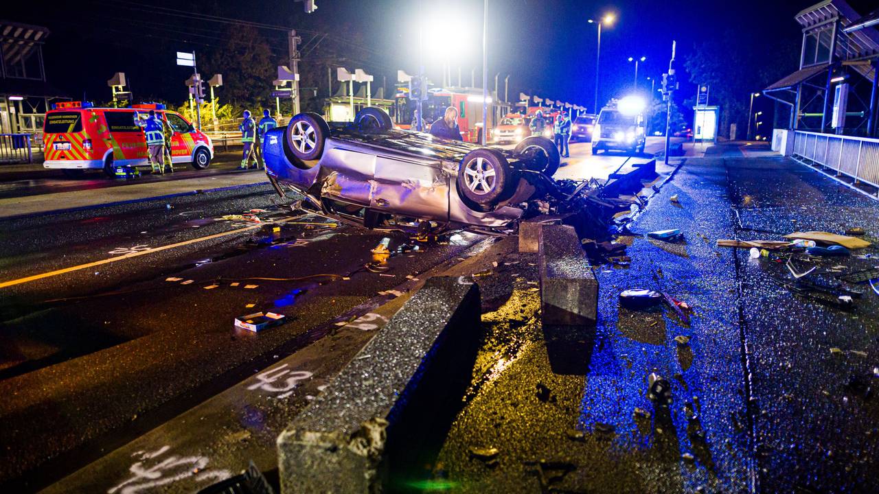 14.09.2025, Niedersachsen, Hannover: Ein verunfalltes Auto liegt auf dem Dach auf einer Brücke hinter Betonbaken. Foto: Moritz Frankenberg/dpa +++ dpa-Bildfunk +++