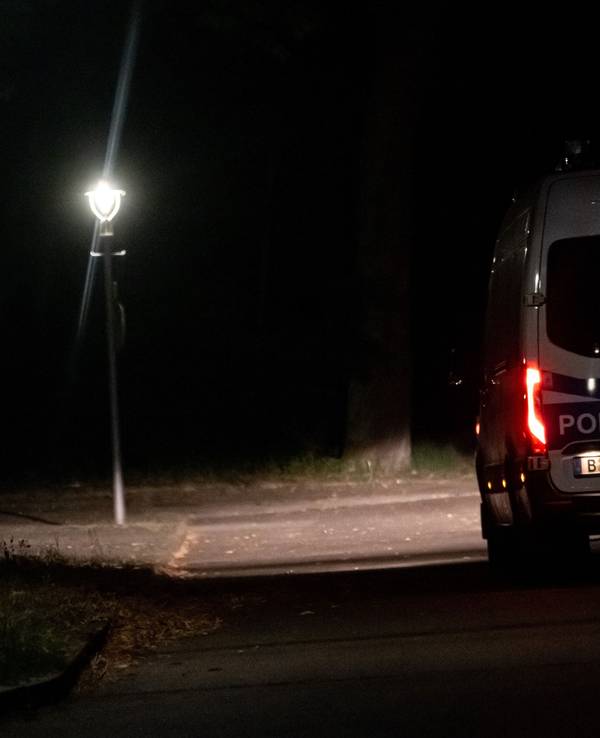 Ein Fahrzeug der Polizei fährt im Dunkeln auf einer Straße