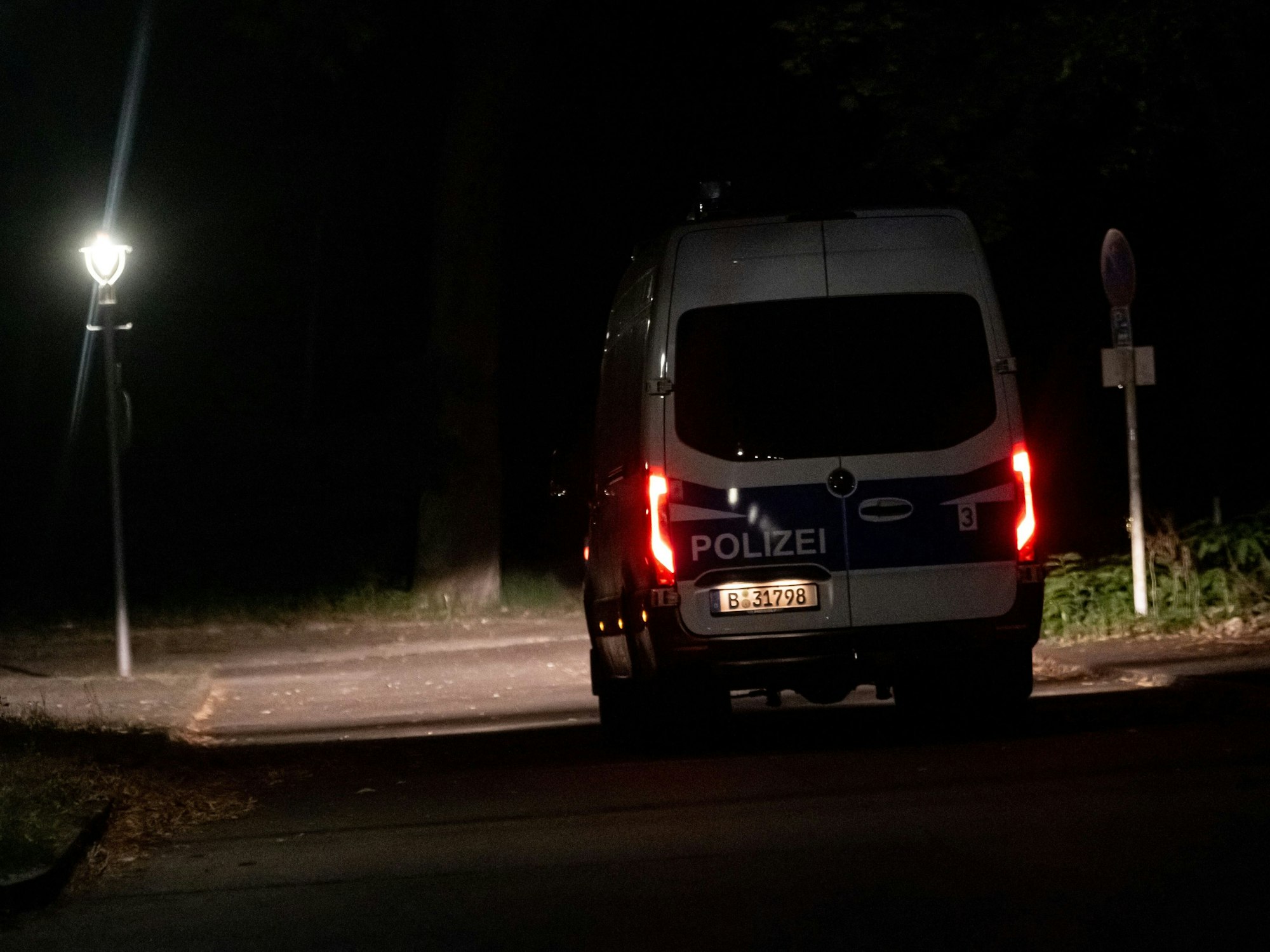 Ein Fahrzeug der Polizei fährt im Dunkeln auf einer Straße