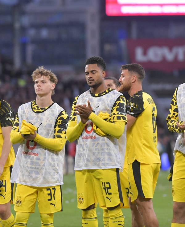 Die BVB-Profis stehen enttäuscht auf dem Platz und applaudieren den Fans.