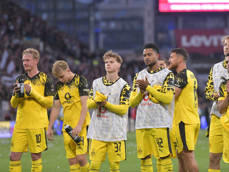 Die BVB-Profis stehen enttäuscht auf dem Platz und applaudieren den Fans.