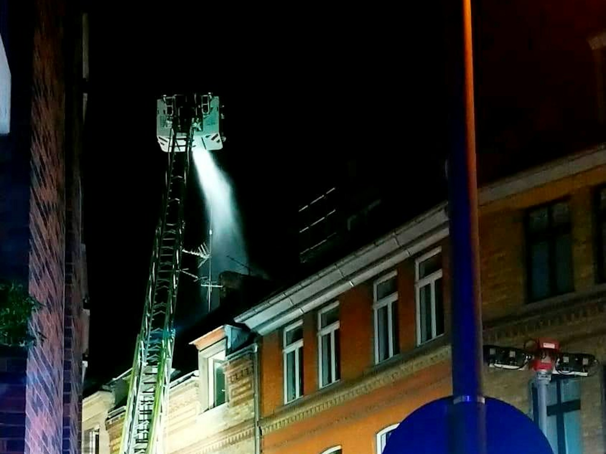 Die Feuerwehr löst über eine Drehleiter einen Dachbrand.