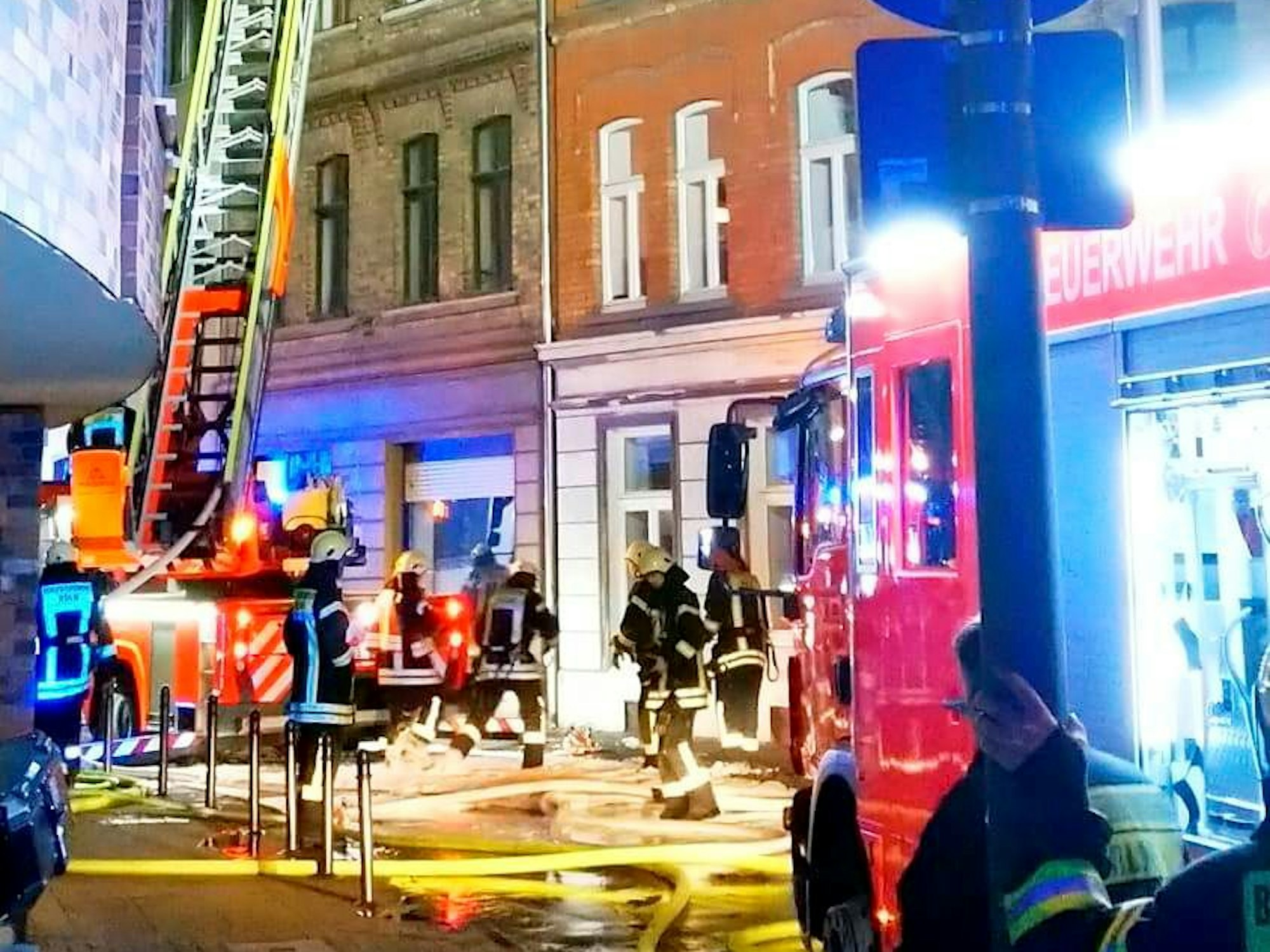 Feuerwehrleute sind an einem Mehrfamilienhaus im Einsatz.