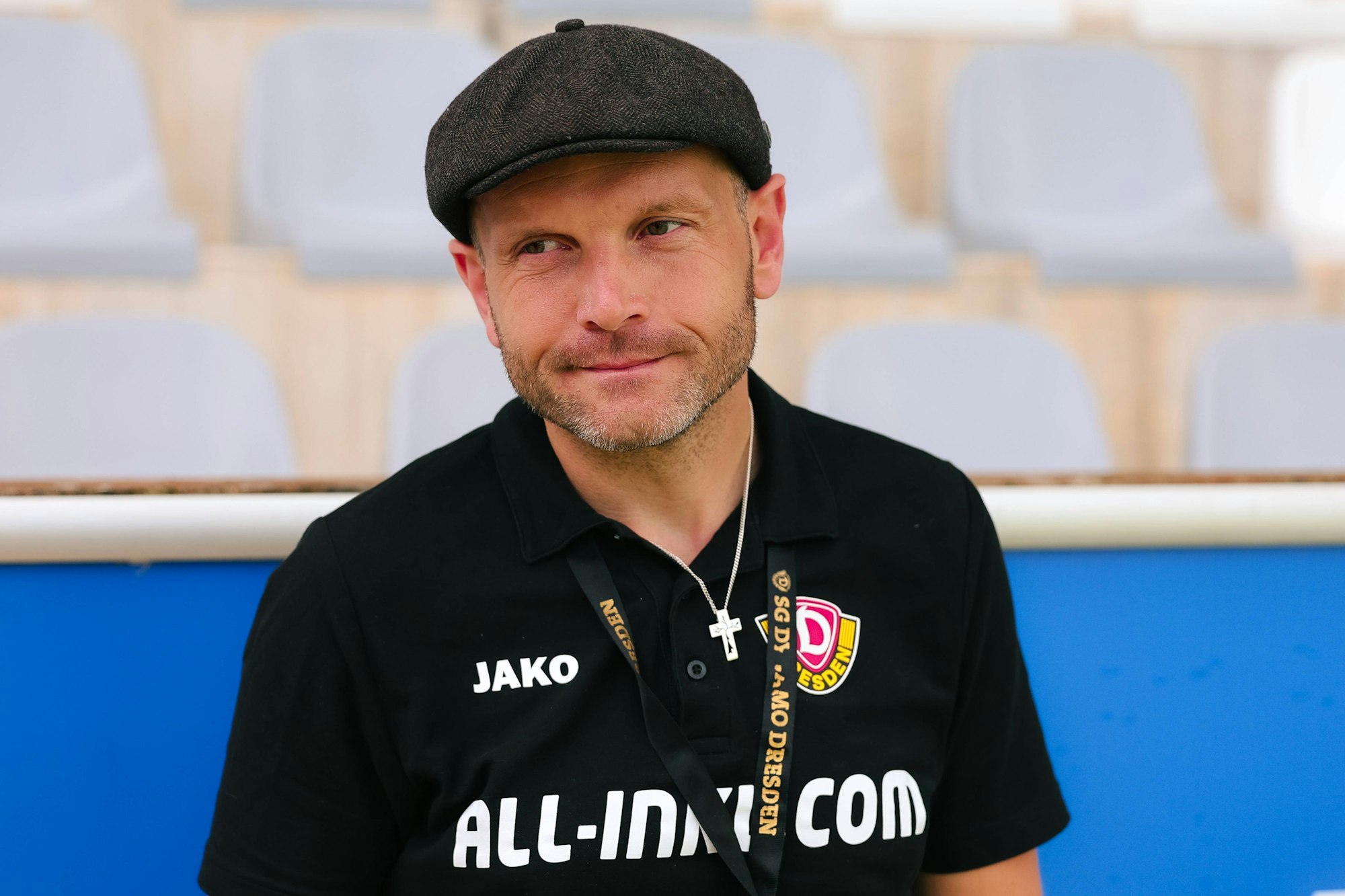 David Fischer steht mit Kappe am Spielfeldrand.