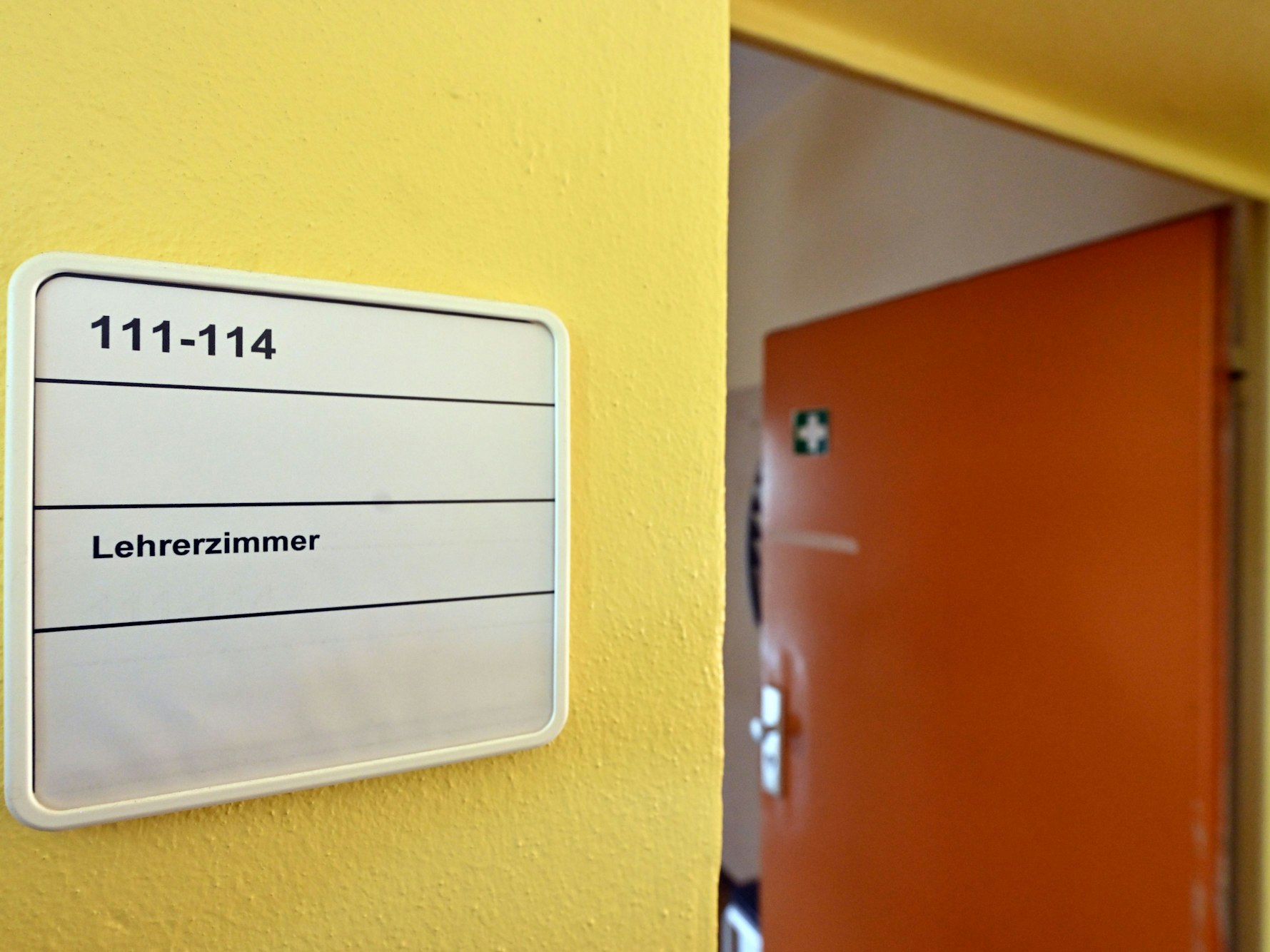 Die Tür zu einem Lehrerzimmer steht offen (Symbolbild):Ein Schuldirektor, der seit fünf Jahren krank ist, ist offiziell Leiter von zwei Gymnasien am Niederrhein.