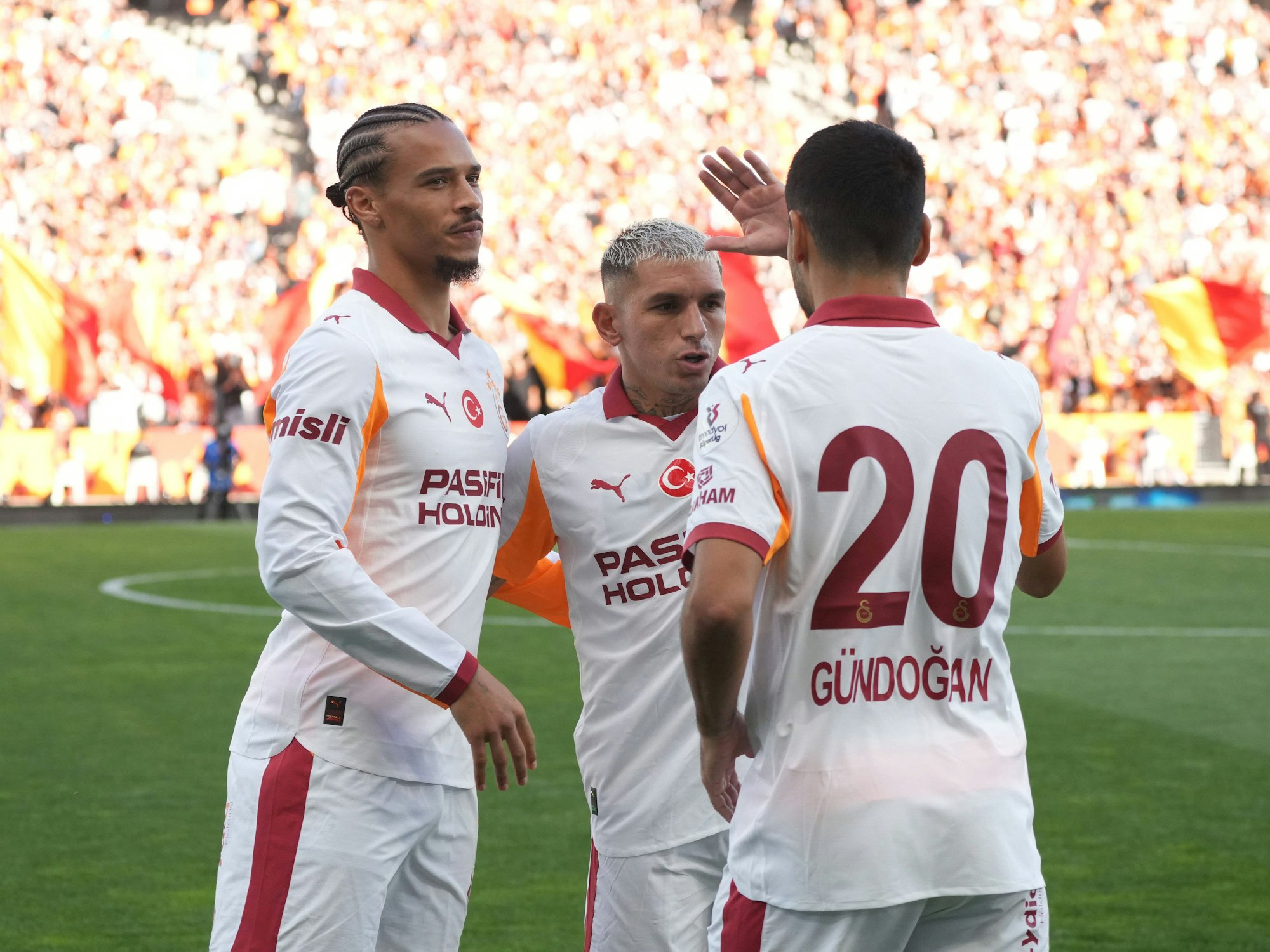 Leroy Sane feiert mit zwei Teamkollegen.