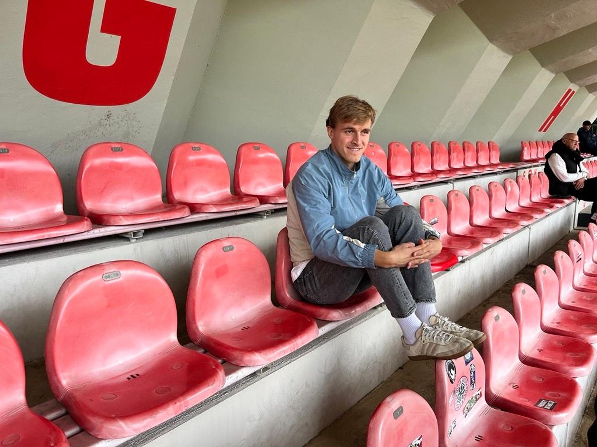 Timo Hübers sitzt auf der Tribüne des Franz-Kremer-Stadions und schaut sich am 17. September 2025 die U23 des 1. FC Köln gegen Borussia Mönchengladbach an.
