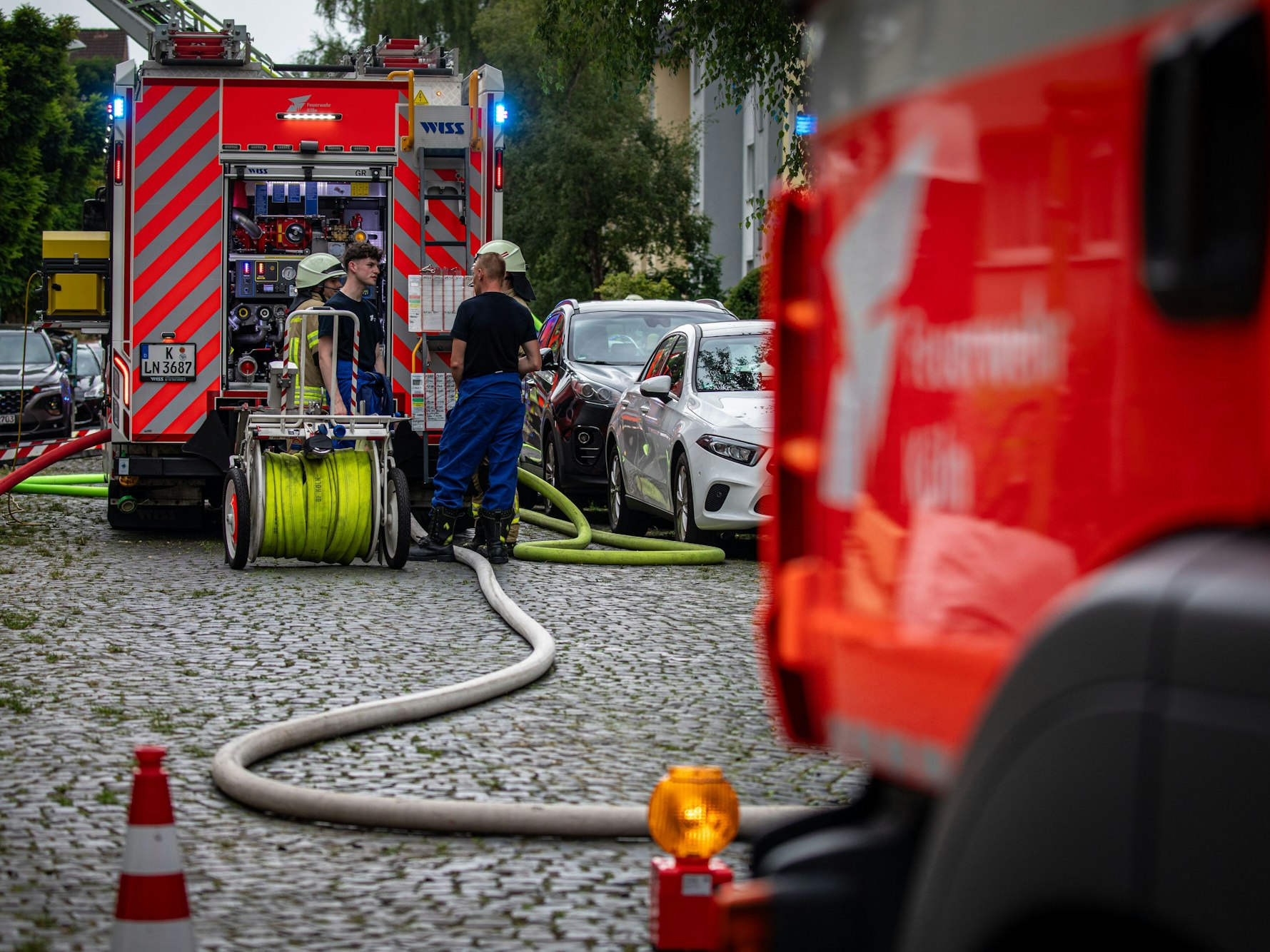 Zwei Feuerwehrfahrzeuge stehen an einer Straße.