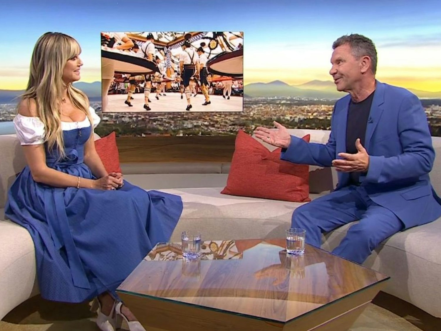 Heidi Klum sitzt auf einem Sofa gegenüber von Moderator Roman Roell.