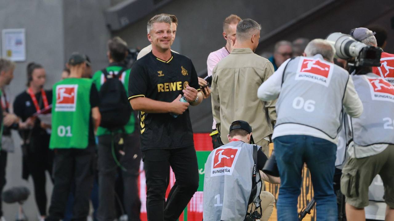 Lukas Kwasniok steht an der Seitenlinie und dreht eine Wasserflasche mit seinen Händen auf.