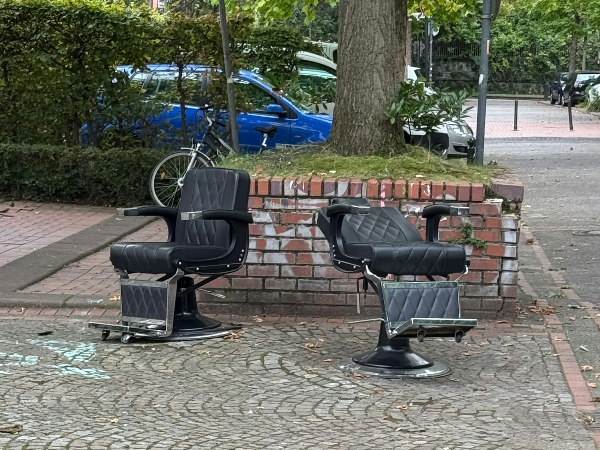 Zwei Stühle stehen an einer Straße.