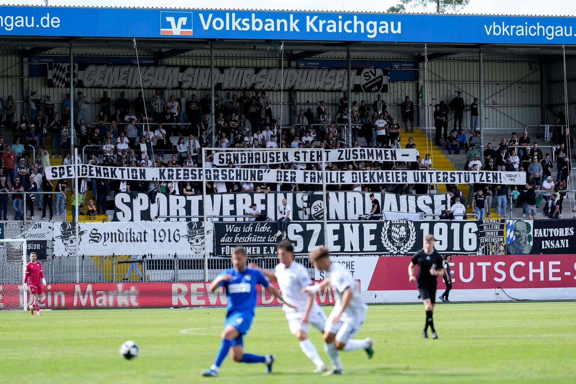 Die Fans vom SV Sandhausen zeigen in der Fankurve ein Banner mit der Aufschrift: „Sandhausen steht zusammen – Spendenaktion Krebsforschung der Familie Diekmeier unterstützen“.