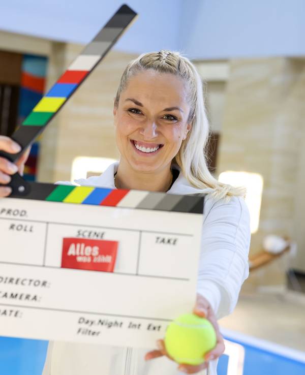 Sabine Lisicki steht mit einer Filmklappe im Filmset der RTL-Vorabendserie „Alles was zählt“.