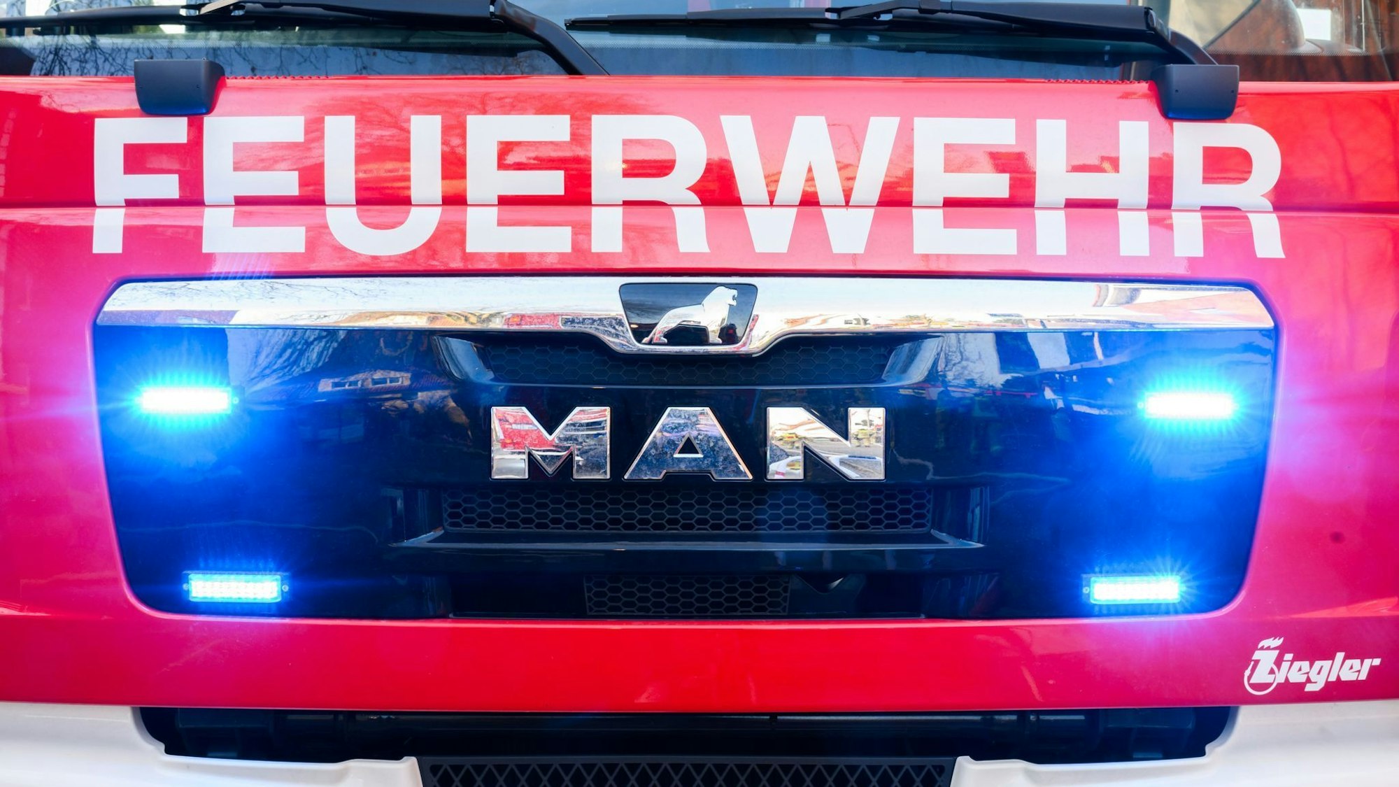 Auf der Front eines Fahrzeugs steht Feuerwehr.