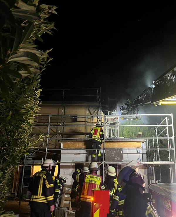 Feuerwehrleute sind nachts im Einsatz wegen eines brennenden Hauses.
