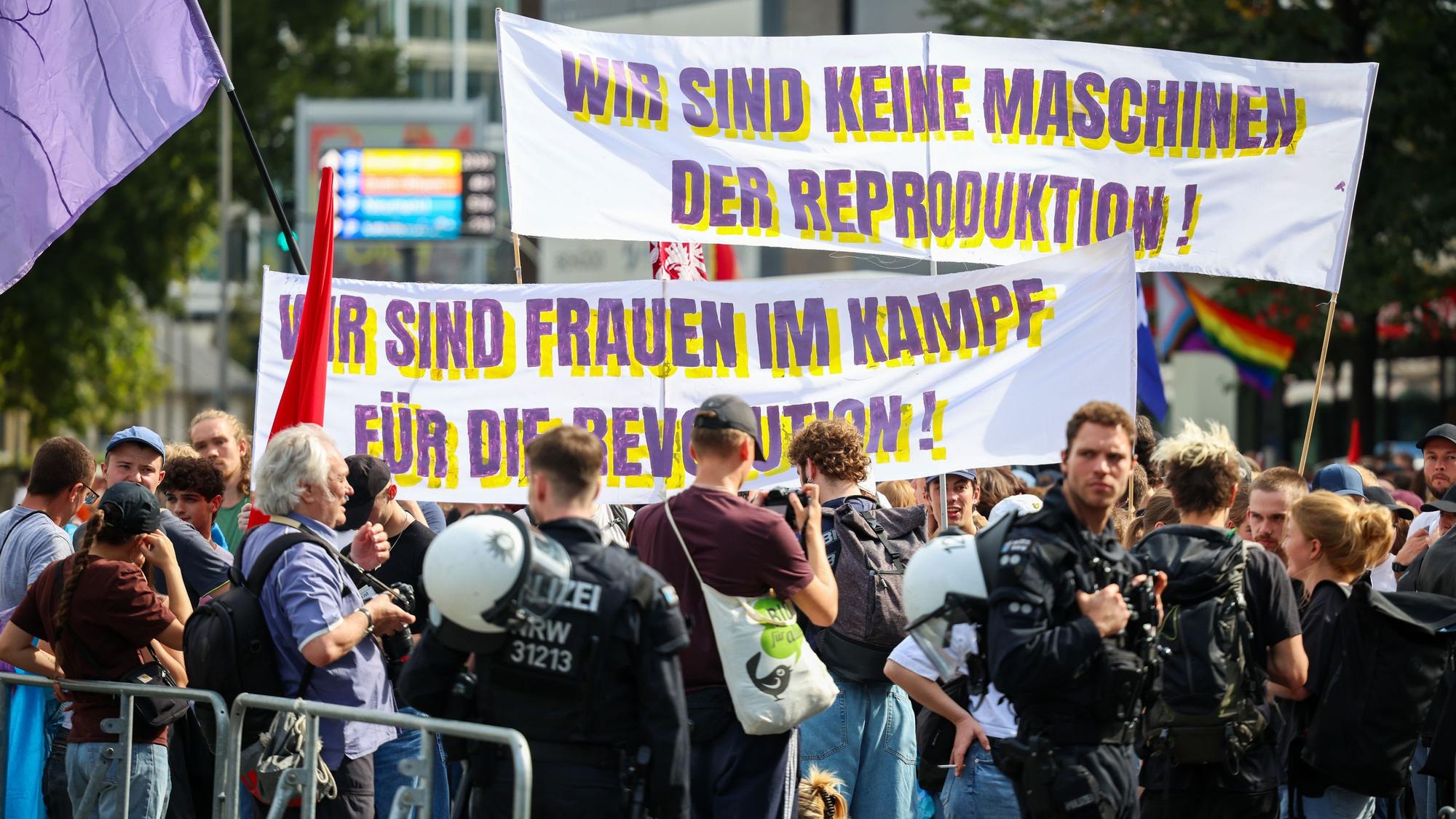 Menschen halten Transparente mit der Aufschrift „Wir sind keine Maschinen der Reproduktion“ und „Wir sind Frauen im Kampf für die Revolution“.