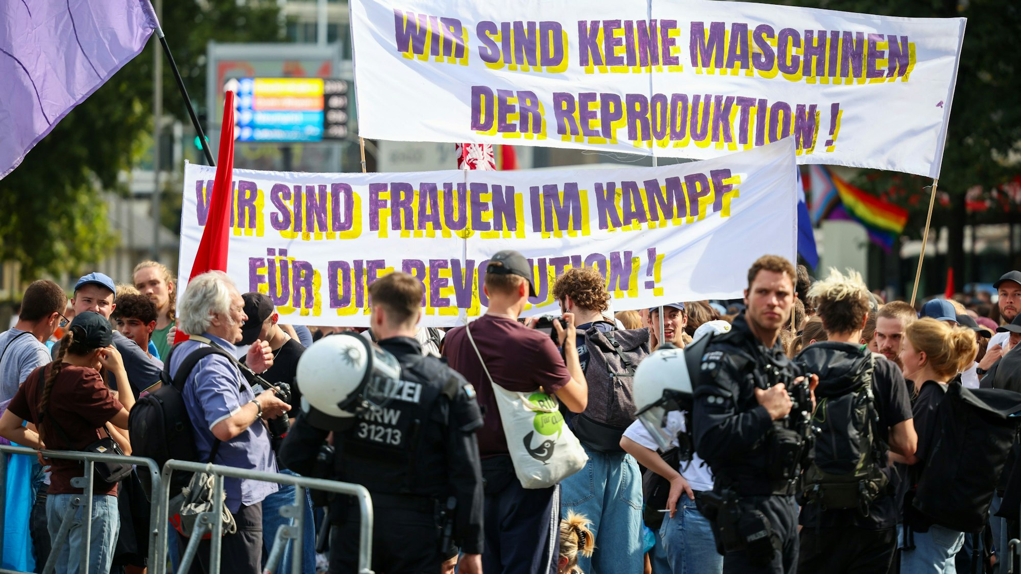 Auf der Gegendemo zeigen Teilnehmer Transparente mit der Aufschrift „Wir sind keine Maschinen der Reproduktion“ und „Wir sind Frauen im Kampf für die Revolution“.