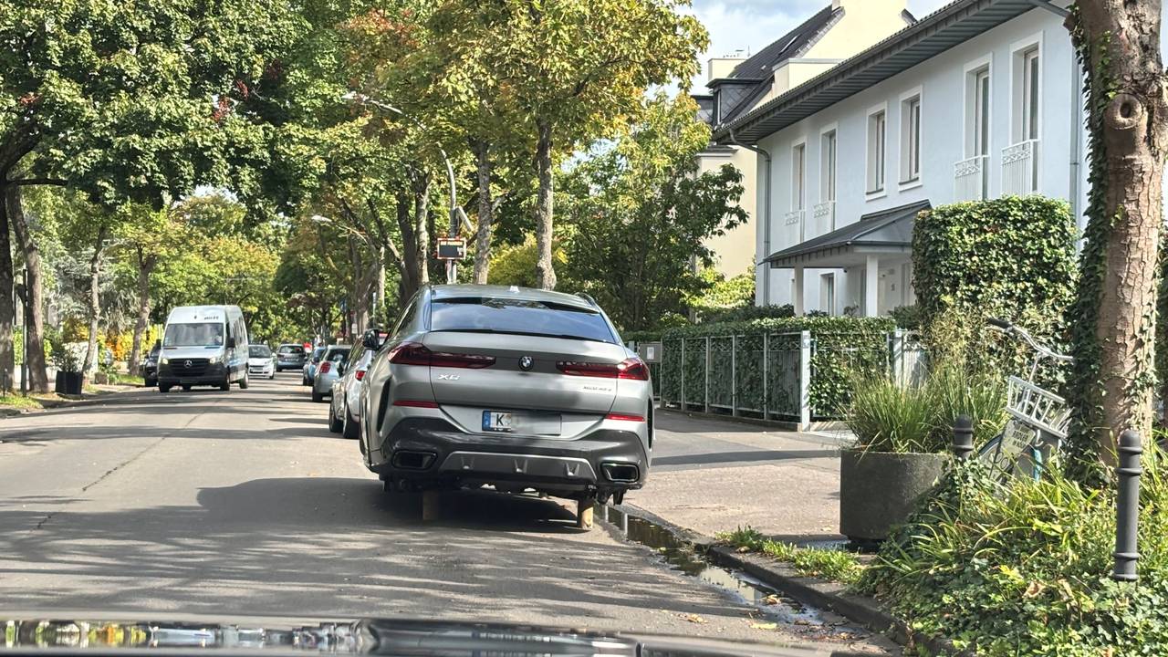 Ein Auto steht statt auf Rädern auf Holzpflöcken.