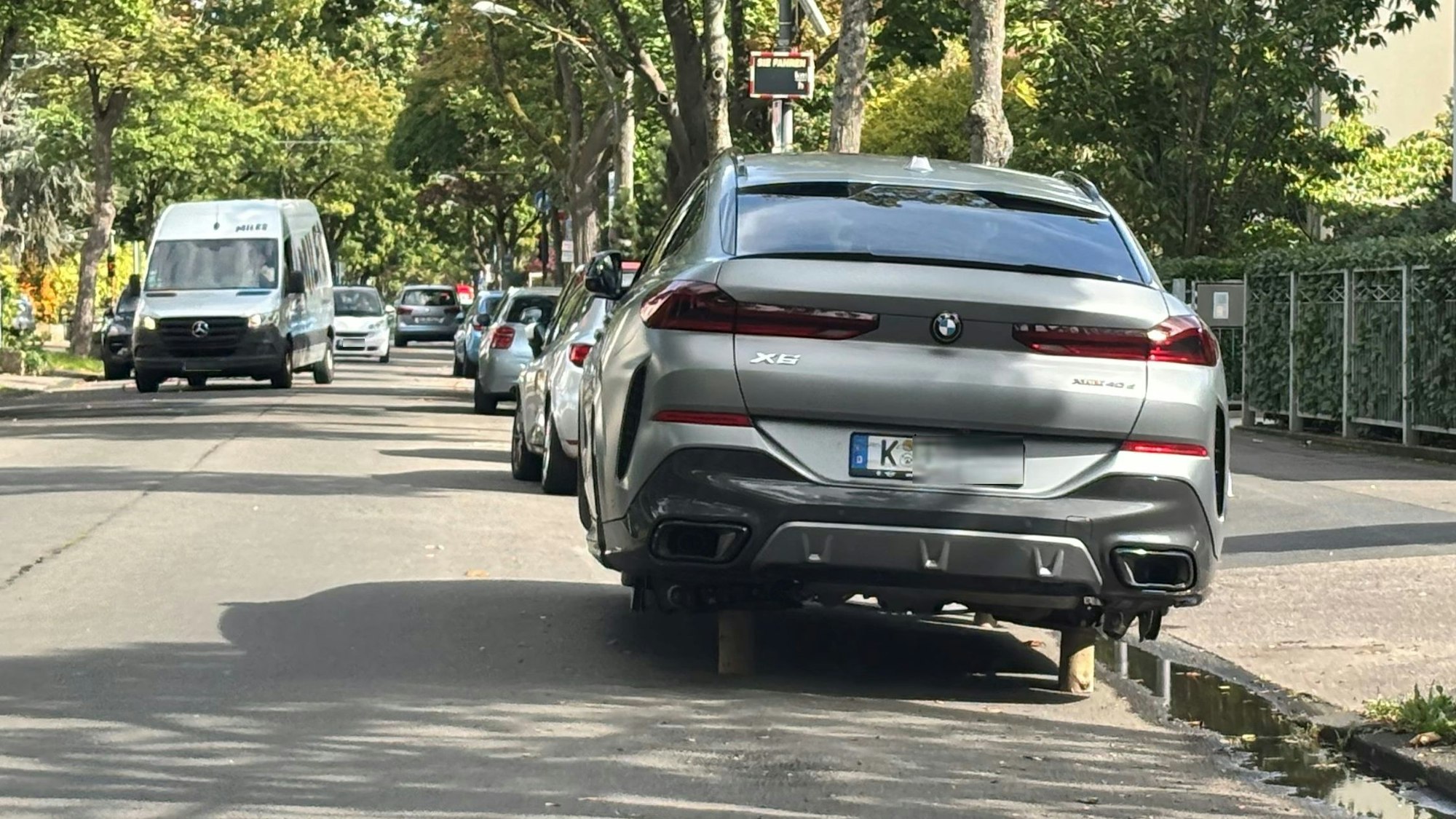 Ein Auto steht statt auf Rädern auf Holzpflöcken.
