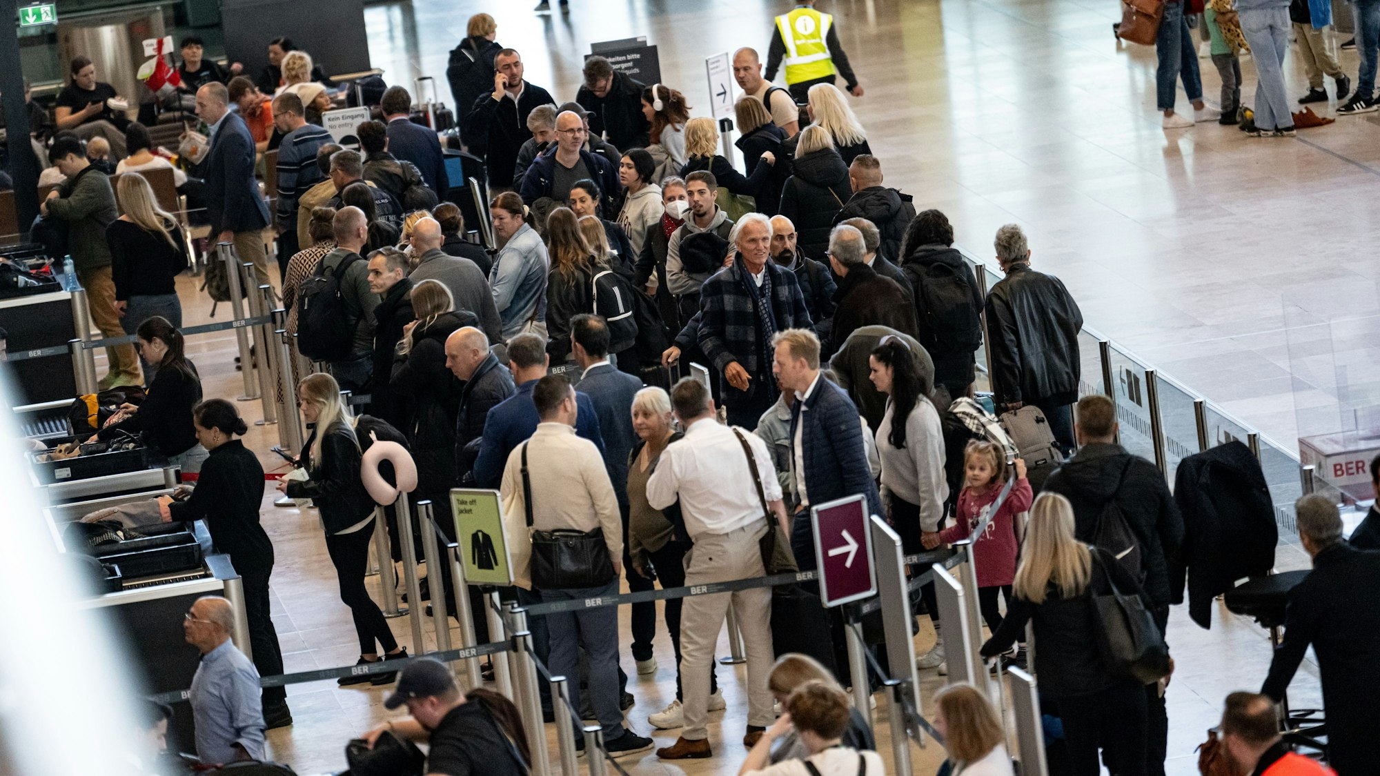 Menschen, die im Oktober 2024 am Flughafen Berlin-Brandenburg (BER) in der Schlange zur Security stehen.