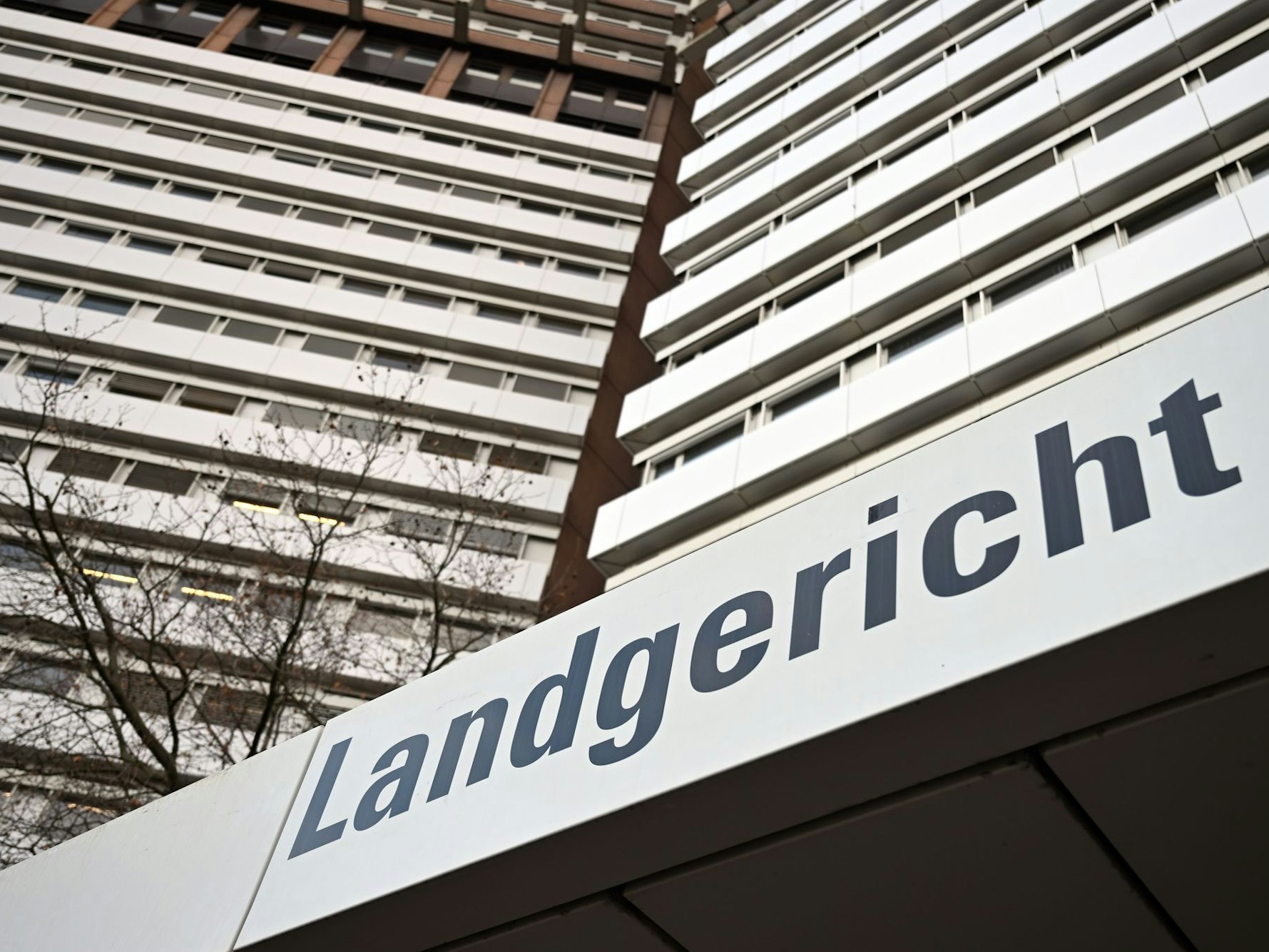 An einem Hochhaus hängt ein Schild mit der Aufschrift Landgericht.