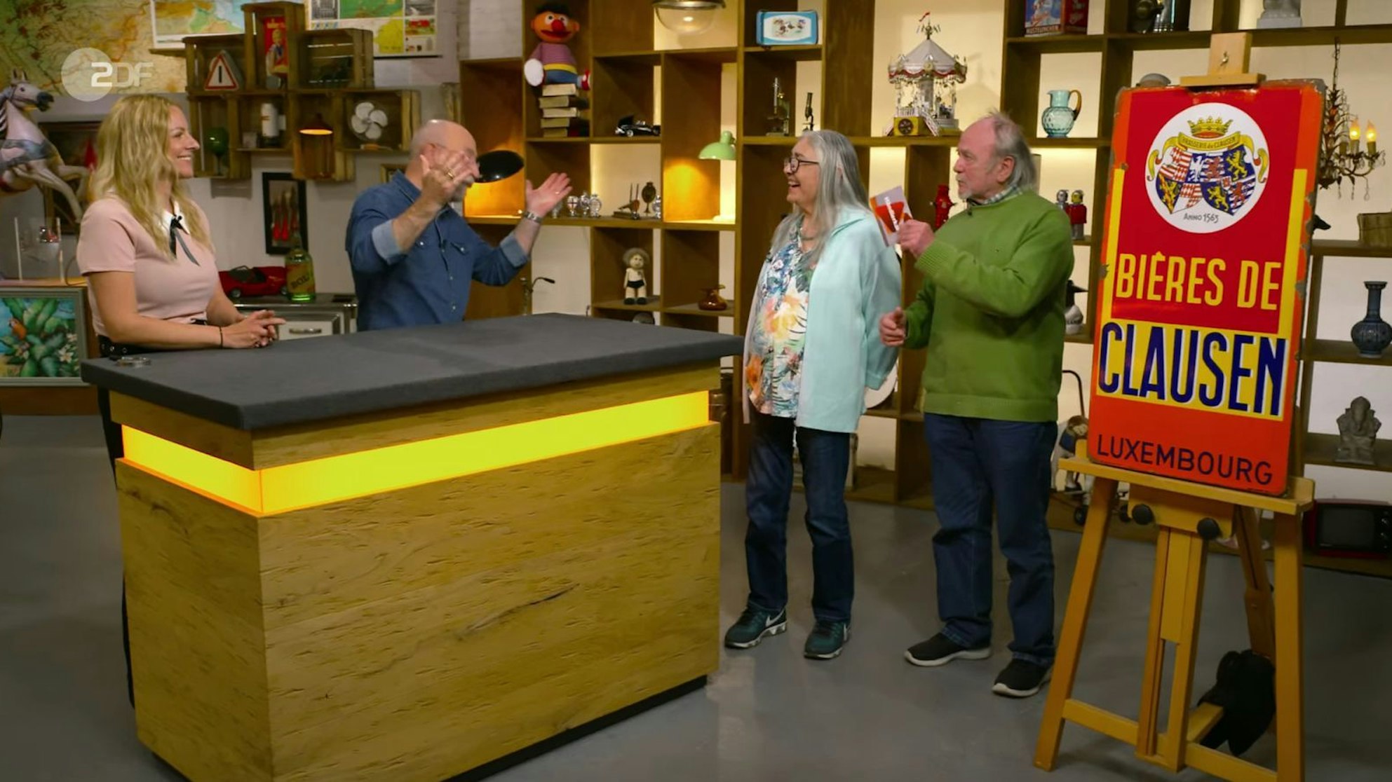 Horst Lichter spielte in der Montagsausgabe der ZDF-Trödelshow „Bares für Rares“ die Rolle des Vermittlers. Denn der Verkäufer wollte viel mehr für sein rostiges Reklameschild, als Expertin Annika Raßbach geschätzt hatte. Die Händlerkarte nahm er letztlich dennoch an - um im Händlerraum weiter zu feilschen ... (Bild: ZDF)