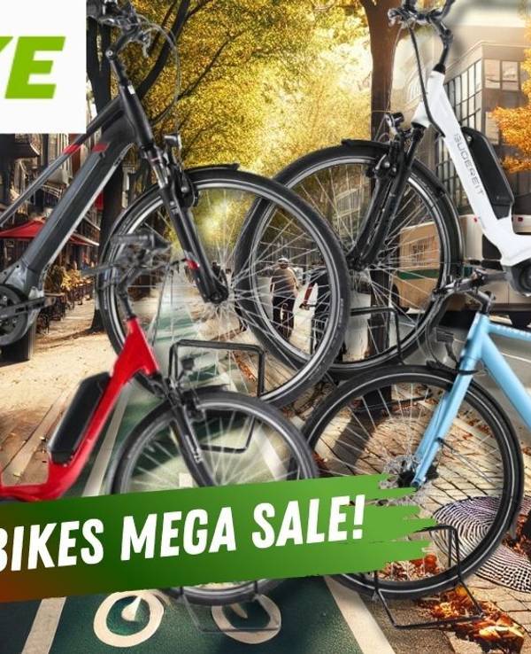 Mehrere City E-Bikes verschiedener Marken vor dem Hintergrund einer Innenstadt im Herbst.