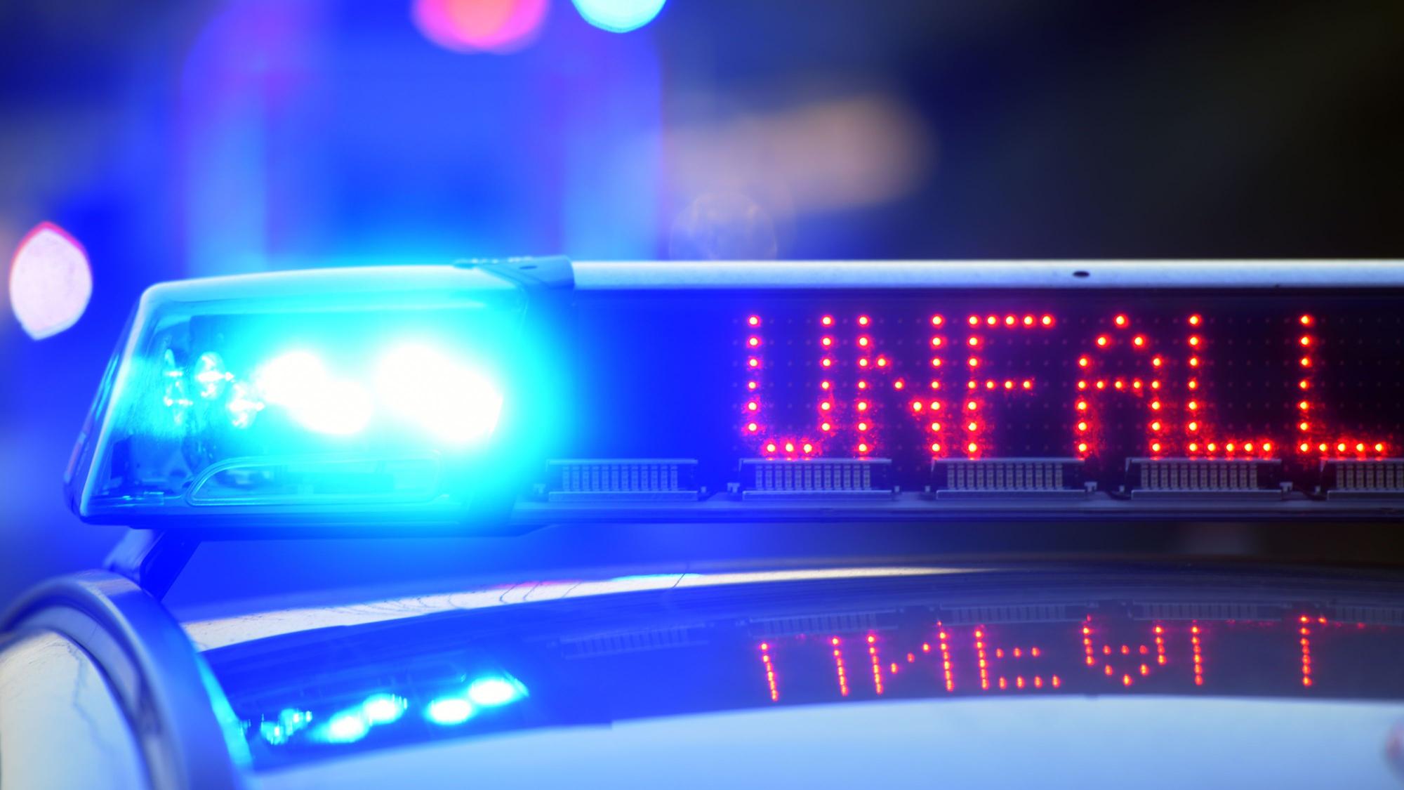 Auf einem Polizeifahrzeug warnt auf der Autobahn eine Leuchtschrift vor einer Unfallstelle.