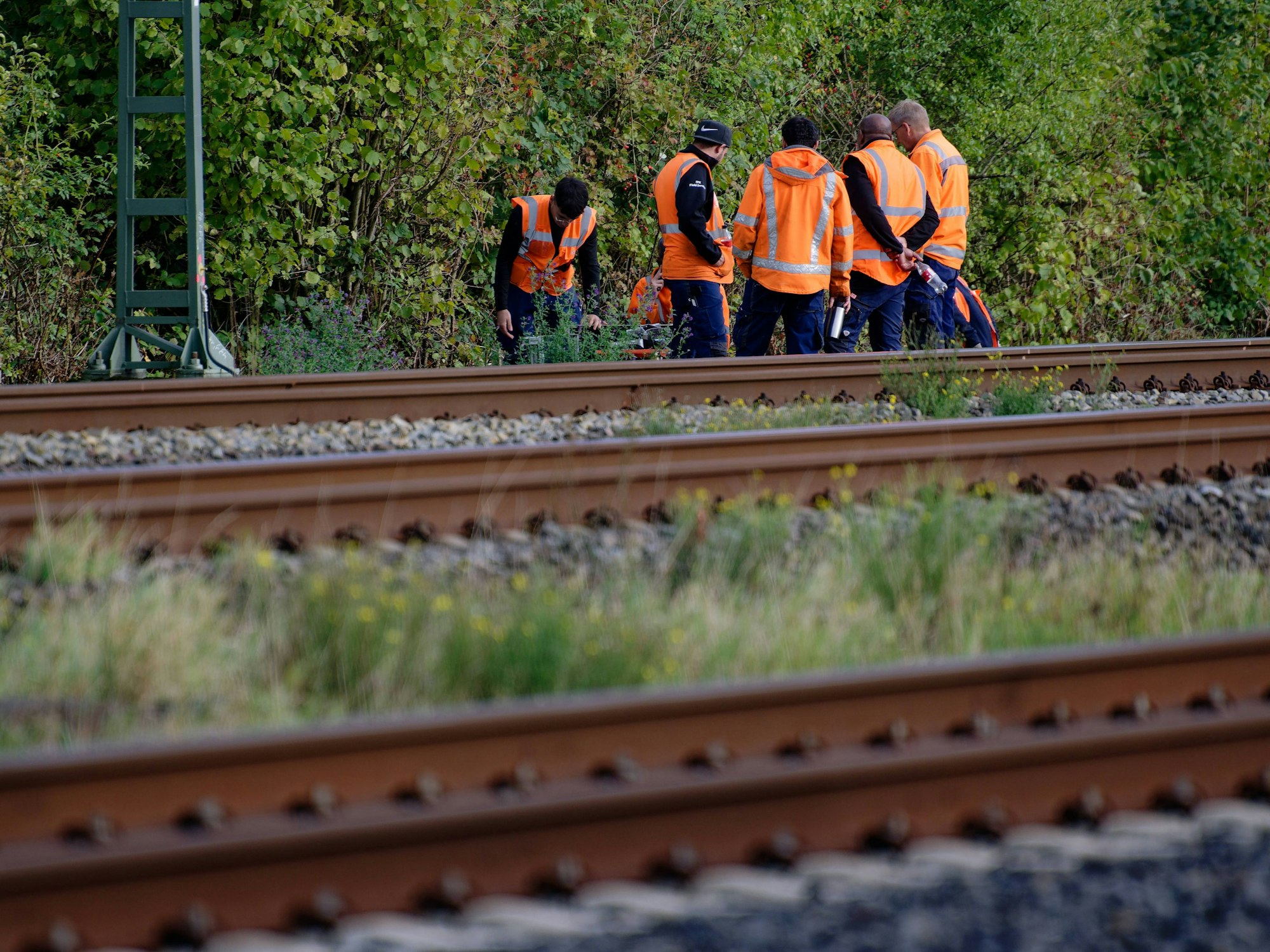 Mitarbeiter der Deutschen Bahn stehen am Rand der Bahnstrecke Köln-Düsseldorf.