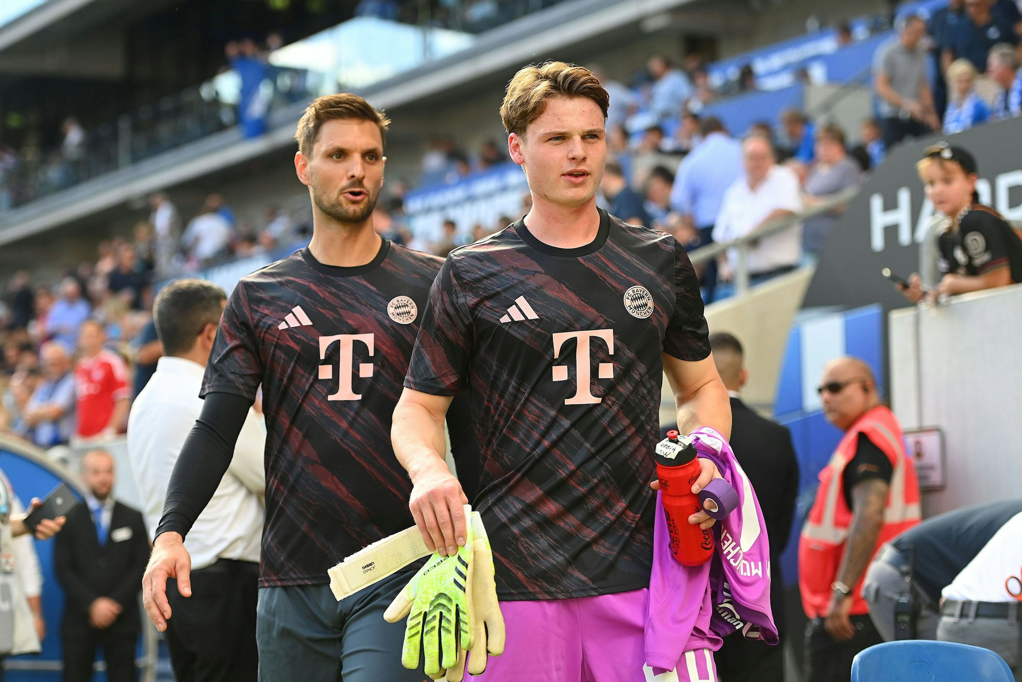 Jonas Urbig und Sven Ulreich gehen zur Bank.