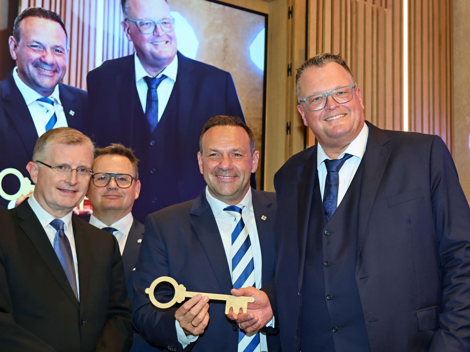 Björn Griesemann hebt einen symbolischen Schlüssel in die Höhe.