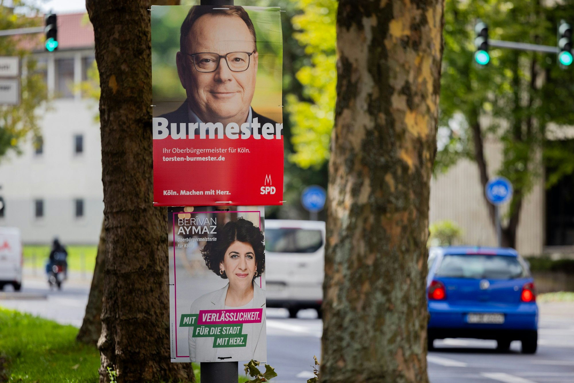 16.09.2025, Nordrhein-Westfalen, Köln: Zwei Wahkplakate zeigen die beiden Kandidaten von SPD, Burmester (oben), und von Bündnis 90/Die Grünen, Aymaz, für die Stichwahl am 28.09.2025 um das Amt des Oberbürgermeisters der Stadt Köln. Foto: Rolf Vennenbernd/dpa - ACHTUNG: Nur zur redaktionellen Verwendung im Zusammenhang mit der aktuellen Berichterstattung +++ dpa-Bildfunk +++