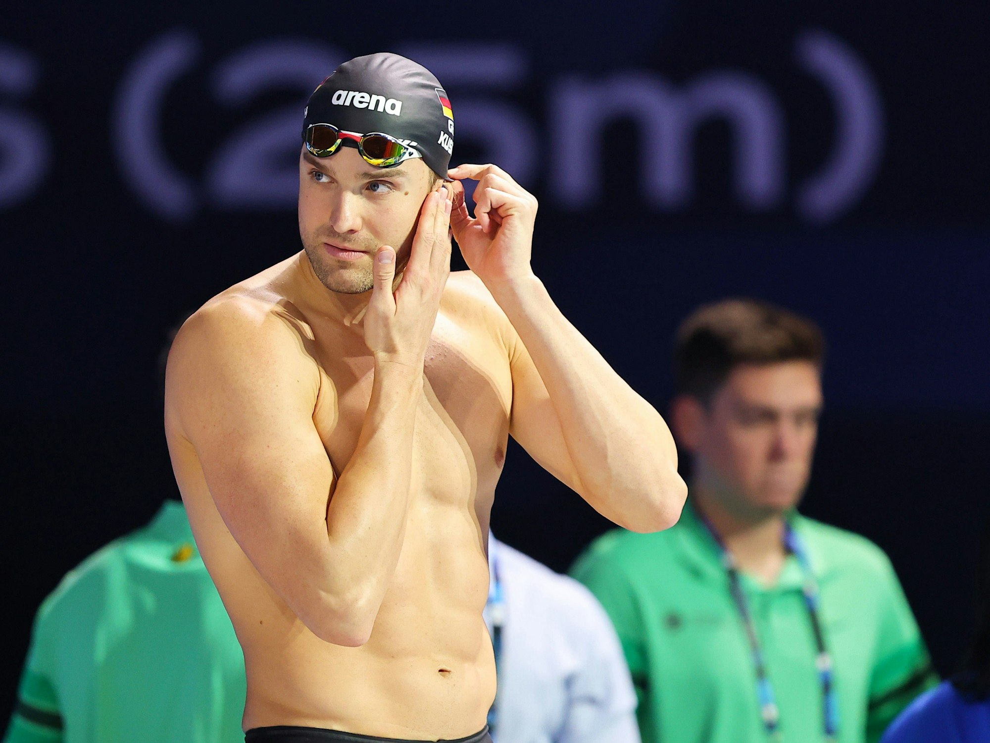 Marius Kusch richtet sich vor einem Wettkampf seine Badekappe.